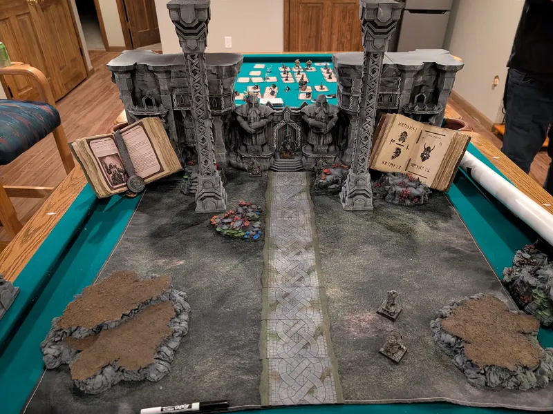 Dwarven fortress terrain with towering pillars and a stone road, set up on a pool table for Matter of Mustaches.