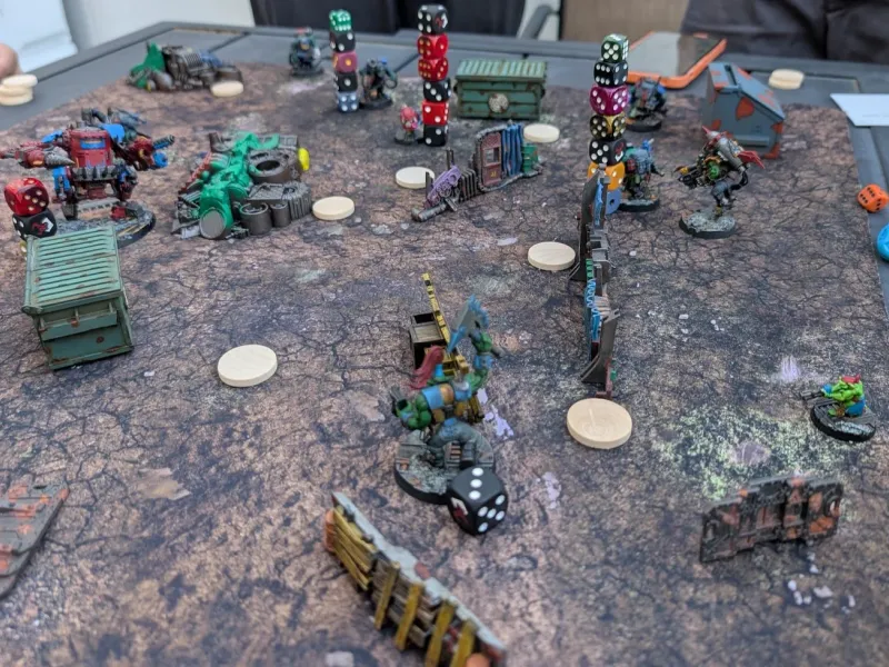 Space Gits warbands spread across a cracked-earth mat, several orks carrying tall stacks of dice on their bases.