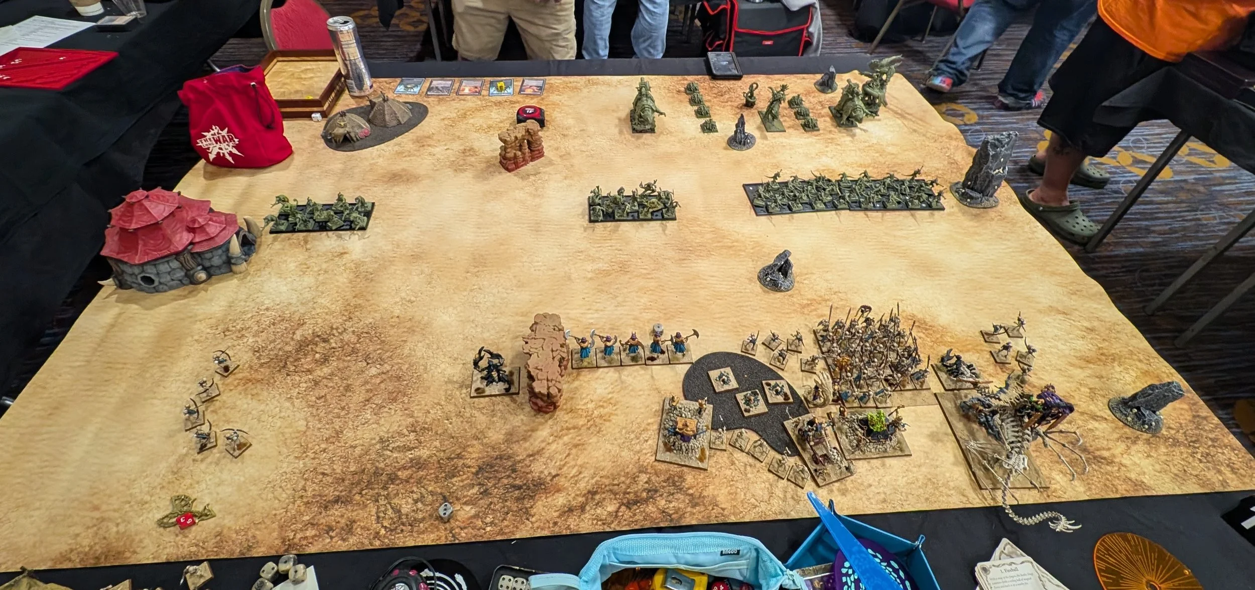 Deployment on a desert table: green Lizardmen regiments spread along the far edge, the Tomb Kings castled up in the near right corner.