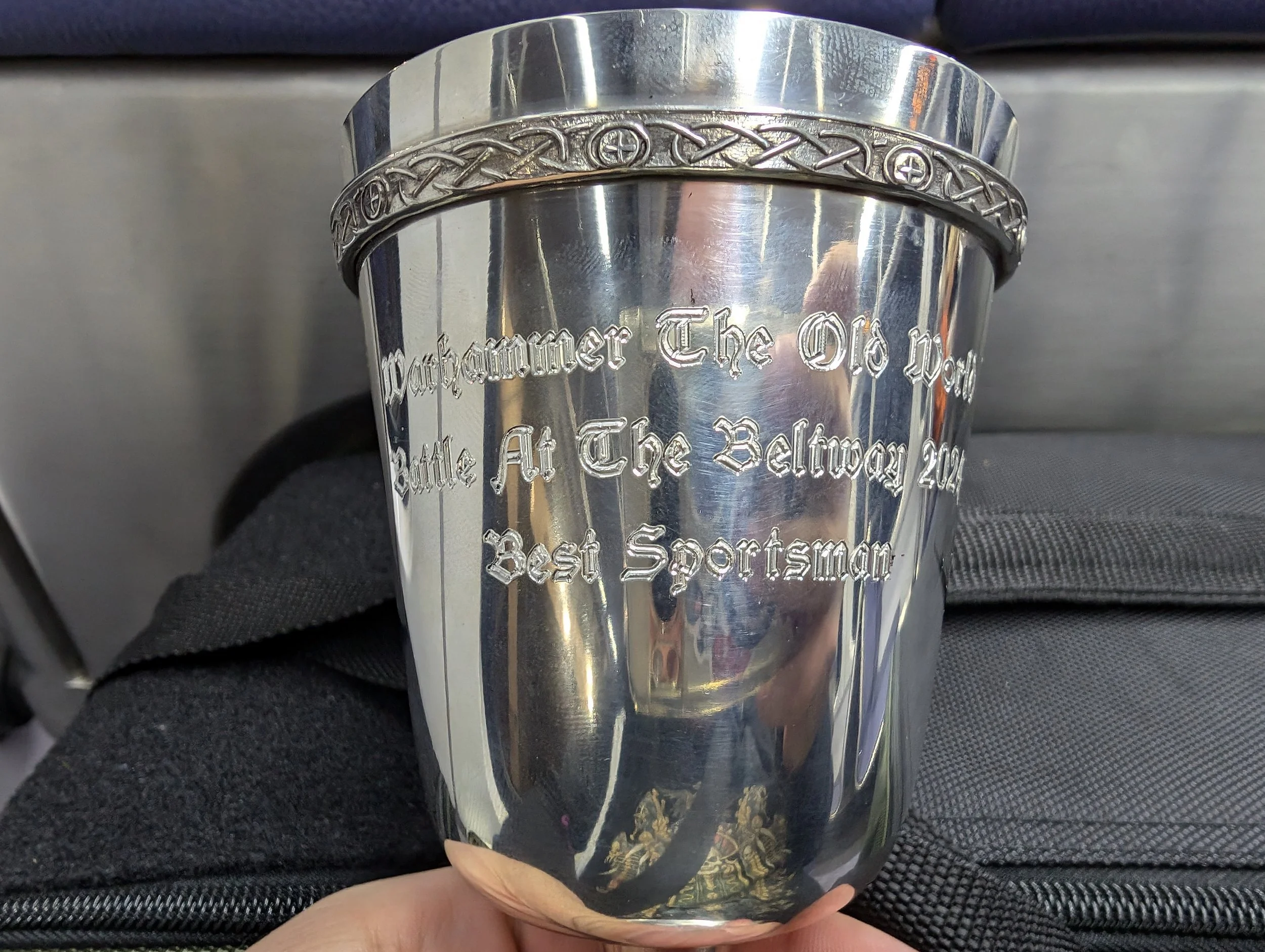 A pewter goblet held up to the camera, engraved "Warhammer The Old World, Battle At The Beltway 2024, Best Sportsman".