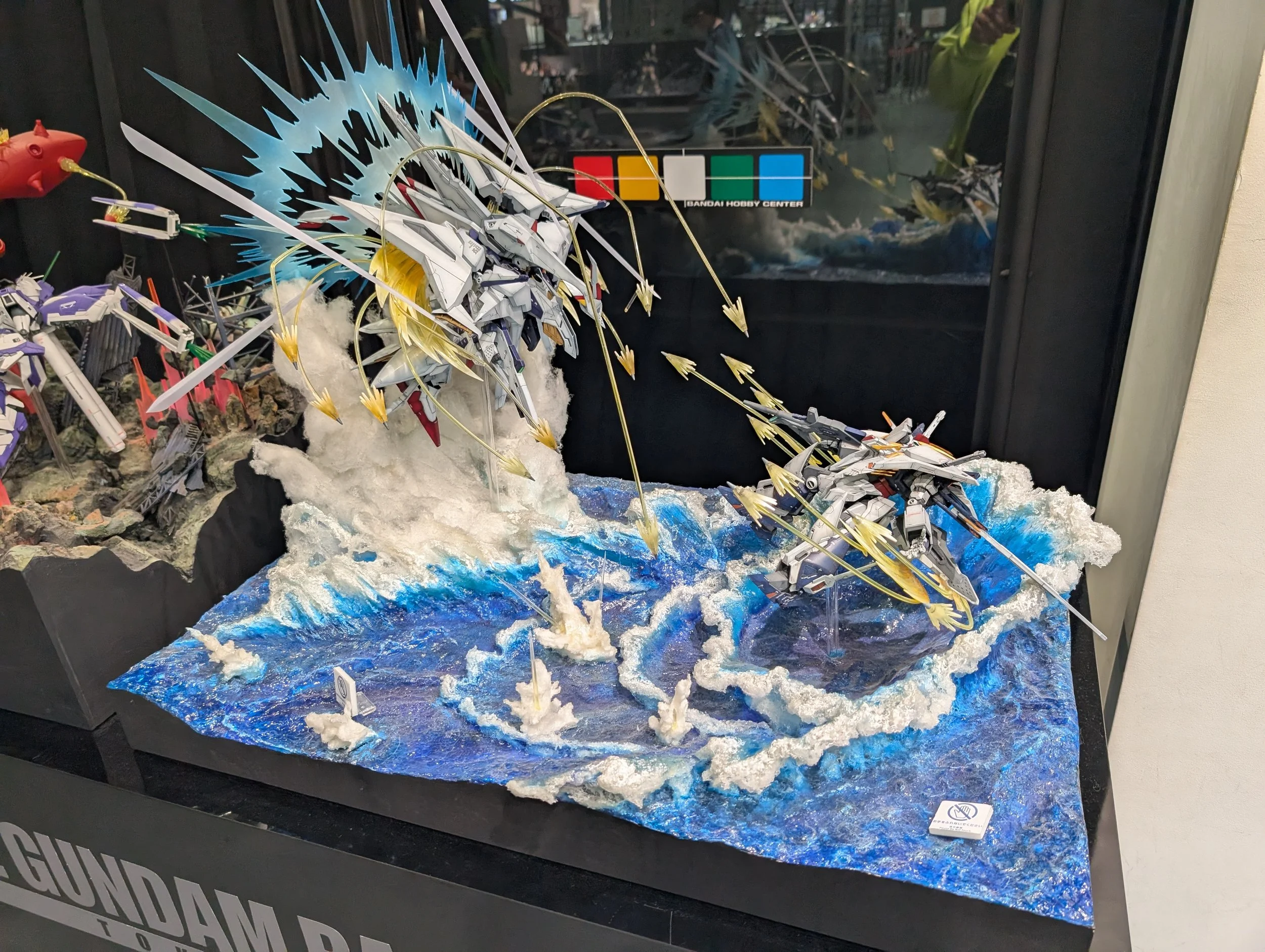 The Unicorn Gundam statue outside Gundam Front Tokyo in daylight.