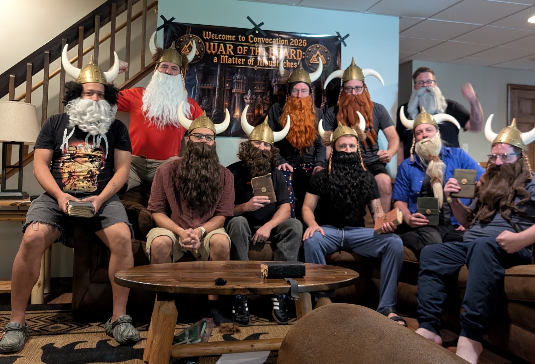 Players wearing costume beards and horned helmets pose together beneath the War of the Beard event banner.
