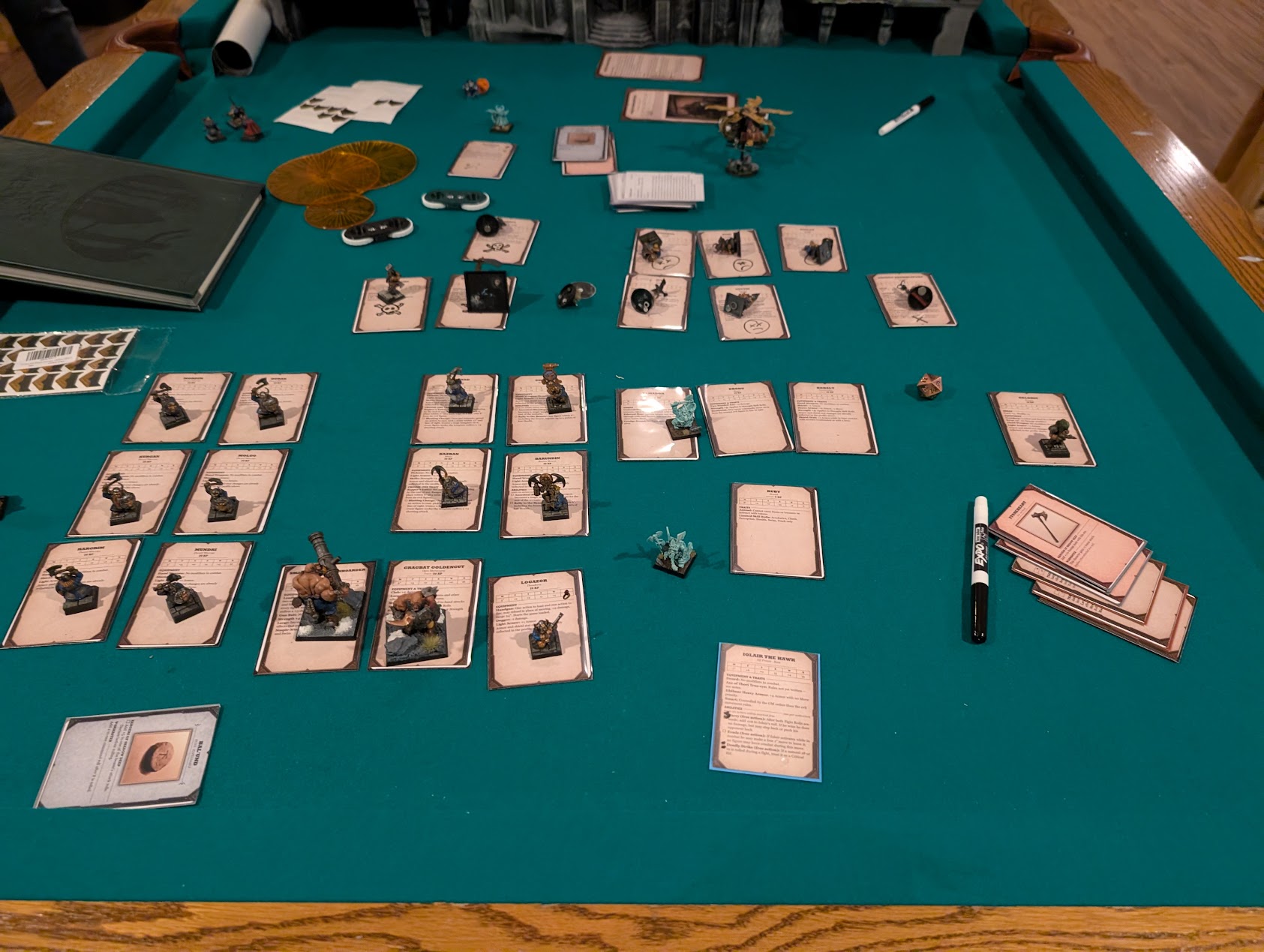 Companion miniatures are arranged beside their reference cards across the green surface of a pool table.