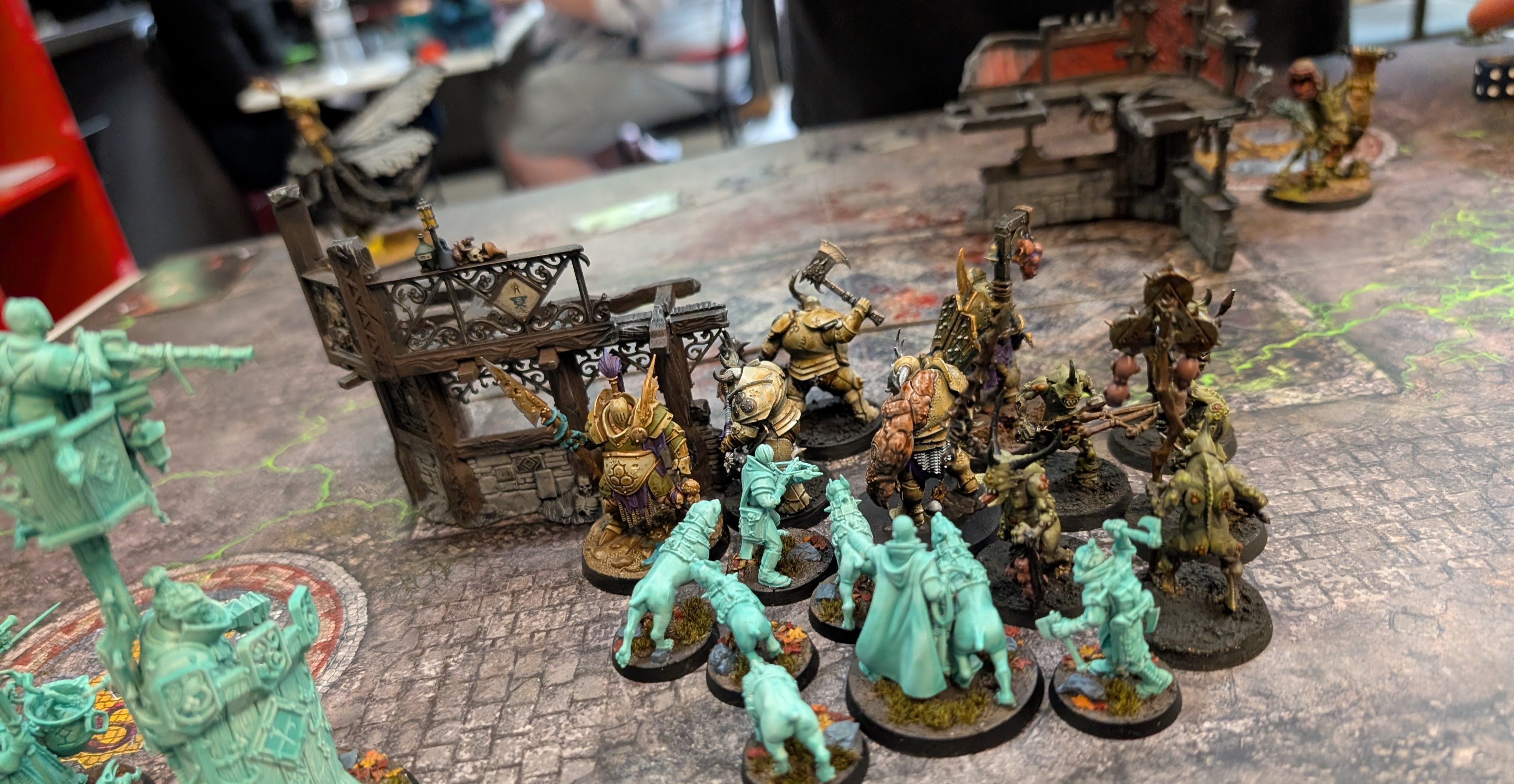 Ghostly turquoise Cities of Sigmar soldiers and hounds face Nurgle warriors beside a ruined building.