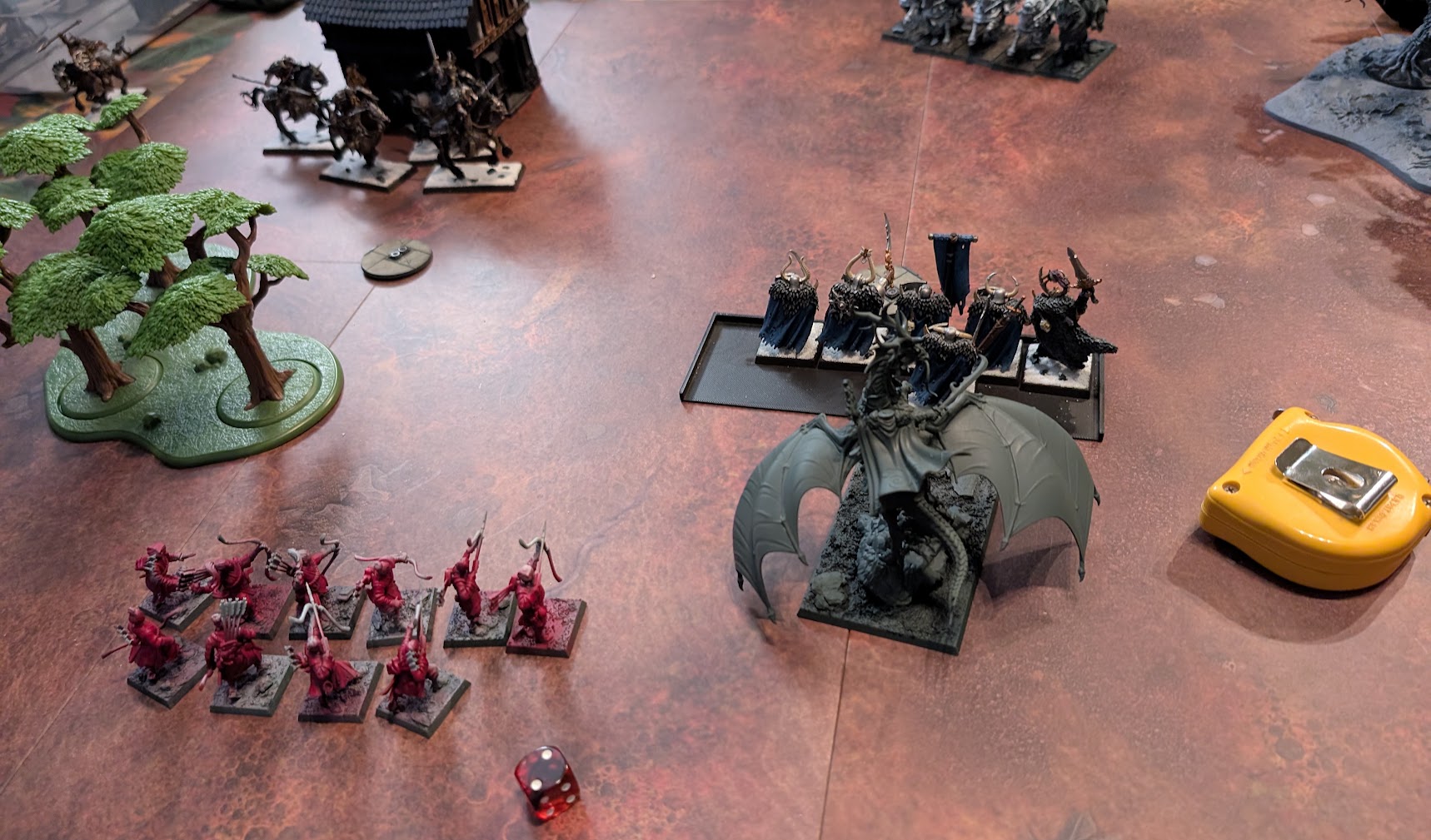 Two miniature armies facing off across a tabletop in a game of Old World: Battle March.