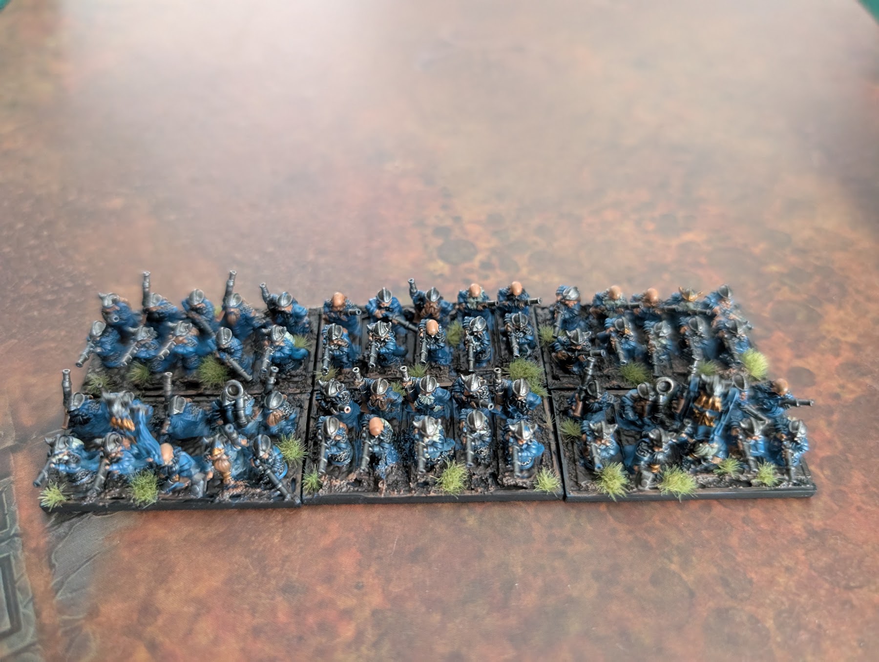 Ranks of painted Empire handgunners in blue coats formed up in units.